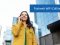 Donna sorridente parla al telefono con Fastweb WiFi Calling, con edifici moderni sullo sfondo.