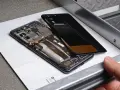 Cellulare aperto, si vede la batteria gonfia, pronta per la sostituzione.