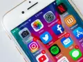 Schermo di un iPhone con icone di app popolari come Facebook, Instagram, Twitter, Netflix e Spotify. Notifiche visibili su alcune app cancellate di recente.