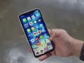 Mano che tiene uno smartphone con icone app. Potrebbe indicare problemi dopo sostituzione display, con alcune icone che appaiono leggermente sfocate o distorte.