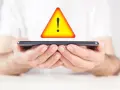 Mani tengono uno smartphone con un segnale di avvertimento giallo sopra. Problema di connessione: iliad non registrato sulla rete.