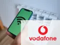 Smartphone con icona Wi-Fi su schermo verde, sovrapposto al logo Vodafone. Un messaggio autoconfigurante Vodafone per la tua connessione.