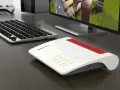 Router Fritz!Box bianco e rosso, con tastiera e monitor. Per sapere come vedere la password del wifi, controlla le impostazioni del router.