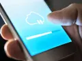 Dito cos'è il backup del cellulare: un'icona di nuvola con frecce indica il caricamento dei dati su uno smartphone, con una barra di avanzamento.
