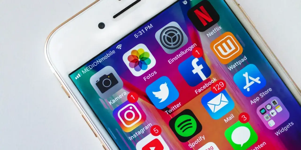 Schermo di un iPhone con icone di app popolari come Facebook, Instagram, Twitter, Netflix e Spotify. Notifiche visibili su alcune app cancellate di recente.