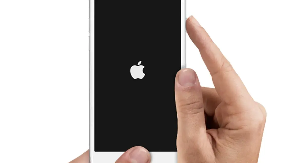 Mani che tengono un iPhone con logo Apple su schermo nero. Il telefono si spegne da solo, forse per un problema.