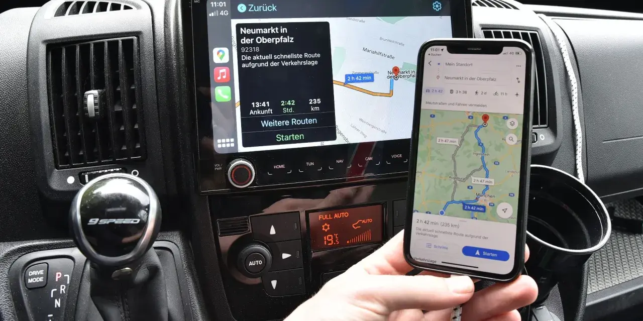 Navigazione in auto con collegamento al telefono. Mappa sul display dell'auto e sullo smartphone mostrano la stessa rotta.