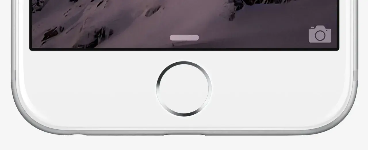 Primo piano di un iPhone bianco con sfondo montuoso. Il tasto home dell'iPhone non funziona, bloccando l'accesso.