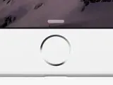Primo piano di un iPhone bianco con sfondo montuoso. Il tasto home dell'iPhone non funziona, bloccando l'accesso.