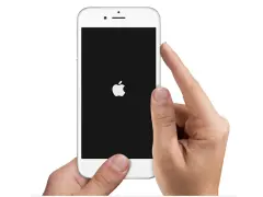 Mani che tengono un iPhone con logo Apple su schermo nero. Il telefono si spegne da solo, forse per un problema.