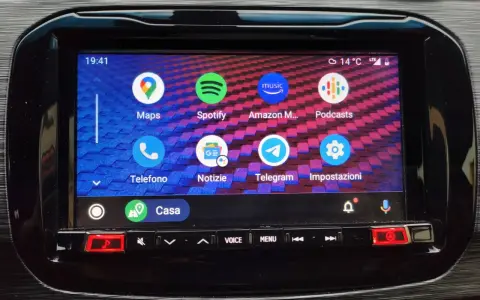 Schermata di Android Auto con icone di app come Maps, Spotify, Telefono e Impostazioni. Per sapere come aggiornare Android Auto, controlla le impostazioni.