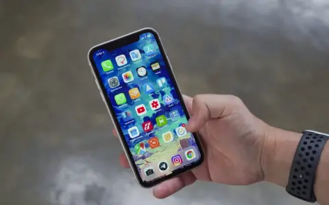 Mano che tiene uno smartphone con icone app. Potrebbe indicare problemi dopo sostituzione display, con alcune icone che appaiono leggermente sfocate o distorte.