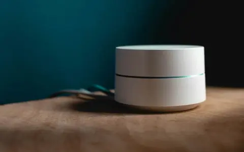 Dispositivo bianco cilindrico con una sottile linea luminosa, cavi sul lato. Sembra un router Wi-Fi non registrato sulla rete.