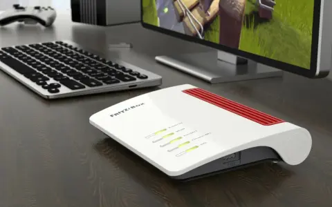 Router Fritz!Box bianco e rosso, con tastiera e monitor. Per sapere come vedere la password del wifi, controlla le impostazioni del router.