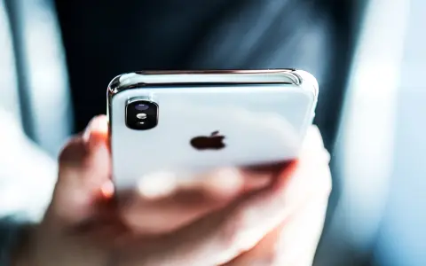 Mani che tengono un iPhone, con il logo Apple visibile. Perfetto per configurare l'APN Spusu e navigare.