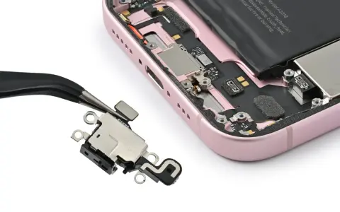 Pinzette rimuovono il connettore di ricarica da un iPhone rosa aperto. Il touch screen iPhone non funziona in parte, forse per questo componente.