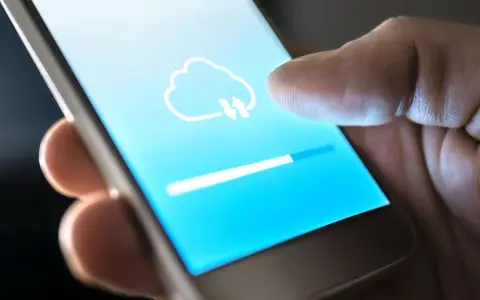Dito cos'è il backup del cellulare: un'icona di nuvola con frecce indica il caricamento dei dati su uno smartphone, con una barra di avanzamento.