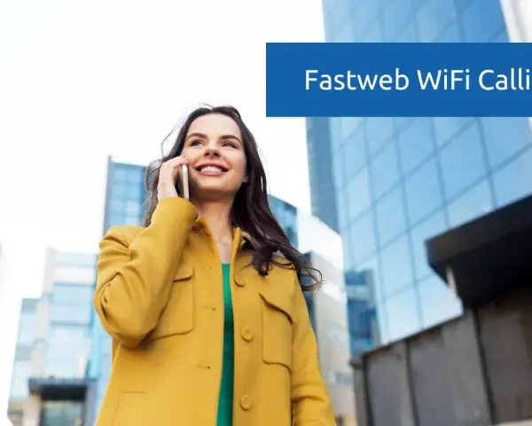 Donna sorridente parla al telefono con Fastweb WiFi Calling, con edifici moderni sullo sfondo.