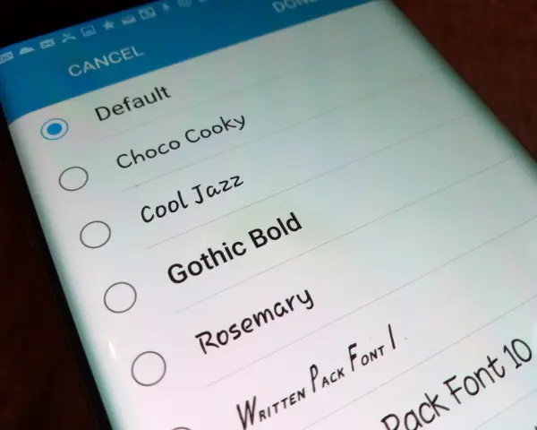 Schermata del telefono che mostra come cambiare scrittura sul telefono, con opzioni come "Default", "Choco Cooky" e "Gothic Bold".