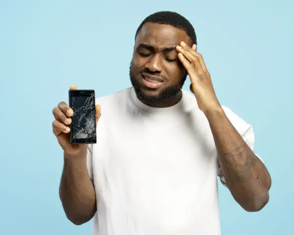 Uomo frustrato mostra il suo telefono con schermo rotto, il touch telefono non funziona.