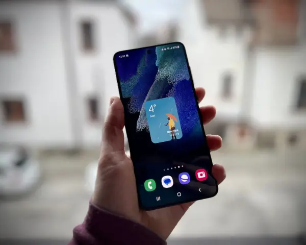 Un widget schermata di blocco Samsung mostra il meteo a New York: 4 gradi e pioggia con un ombrello giallo.