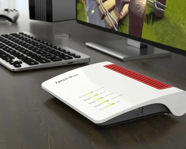 Router Fritz!Box bianco e rosso, con tastiera e monitor. Per sapere come vedere la password del wifi, controlla le impostazioni del router.