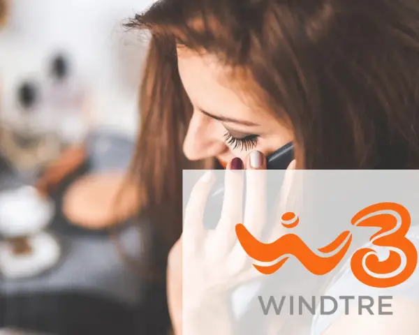 Donna al telefono, con logo Windtre. Scopri i telefoni compatibili per il wifi calling Windtre.