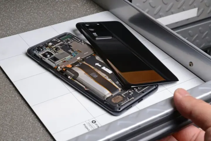 Cellulare aperto, si vede la batteria gonfia, pronta per la sostituzione.