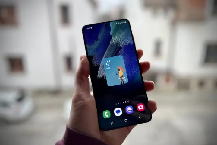 Un widget schermata di blocco Samsung mostra il meteo a New York: 4 gradi e pioggia con un ombrello giallo.