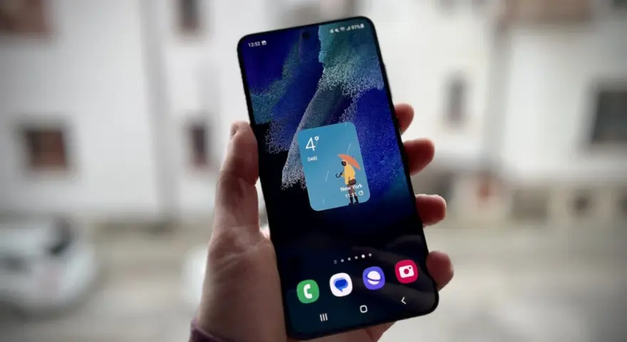 Un widget schermata di blocco Samsung mostra il meteo a New York: 4 gradi e pioggia con un ombrello giallo.