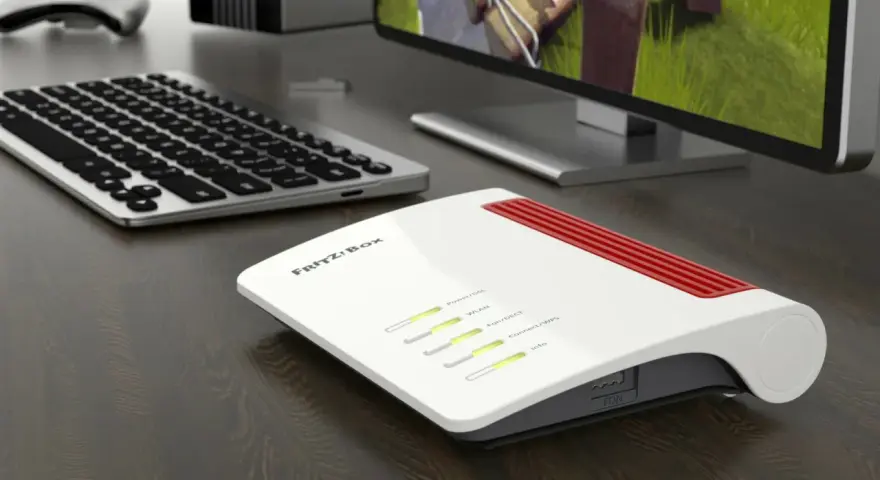 Router Fritz!Box bianco e rosso, con tastiera e monitor. Per sapere come vedere la password del wifi, controlla le impostazioni del router.