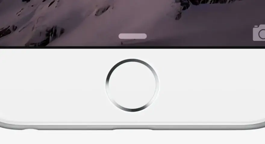 Primo piano di un iPhone bianco con sfondo montuoso. Il tasto home dell'iPhone non funziona, bloccando l'accesso.