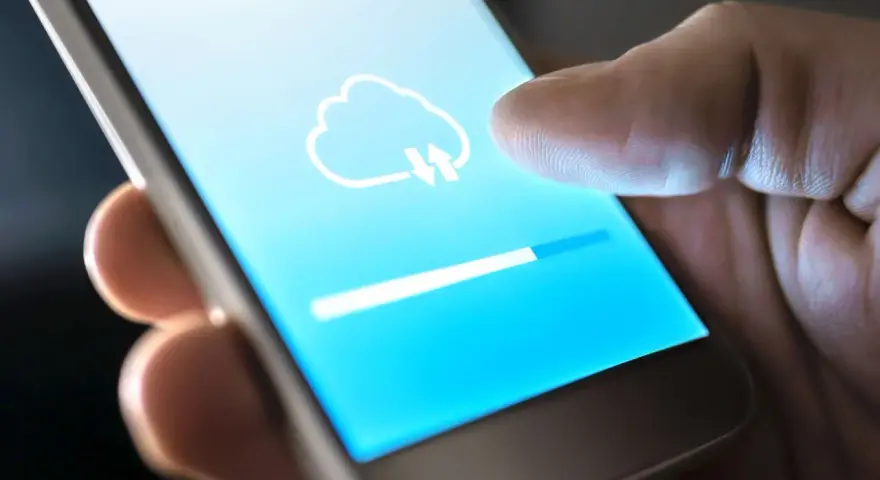 Dito cos'è il backup del cellulare: un'icona di nuvola con frecce indica il caricamento dei dati su uno smartphone, con una barra di avanzamento.