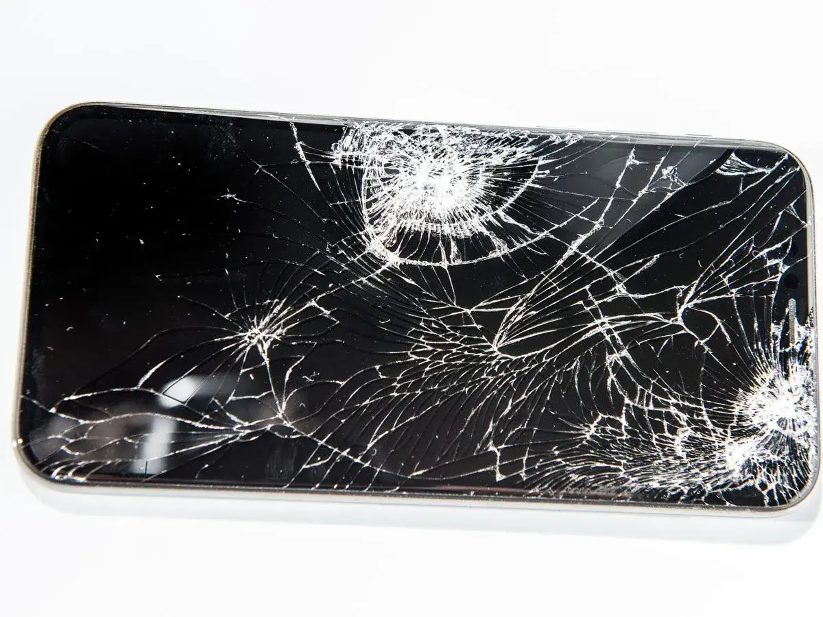 Cellulare caduto con schermo a righe, un disastro visibile.