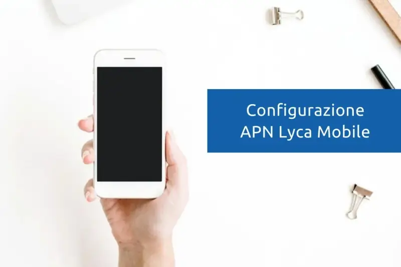 Configurazione APN Lycamobile Italia: mano che tiene uno smartphone bianco con schermo nero, su sfondo bianco con graffette.